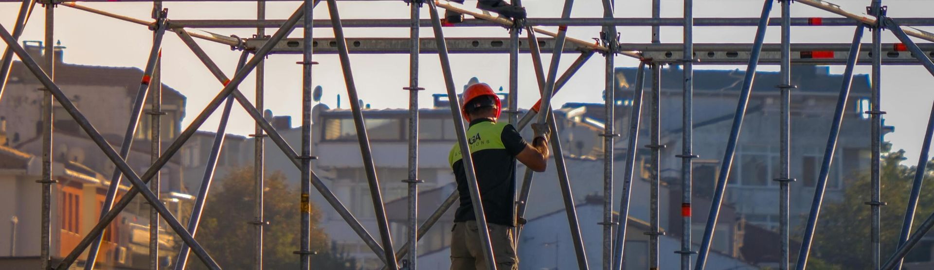 Construction workers on scaffolding at a building site, demonstrating cooperation and safety.